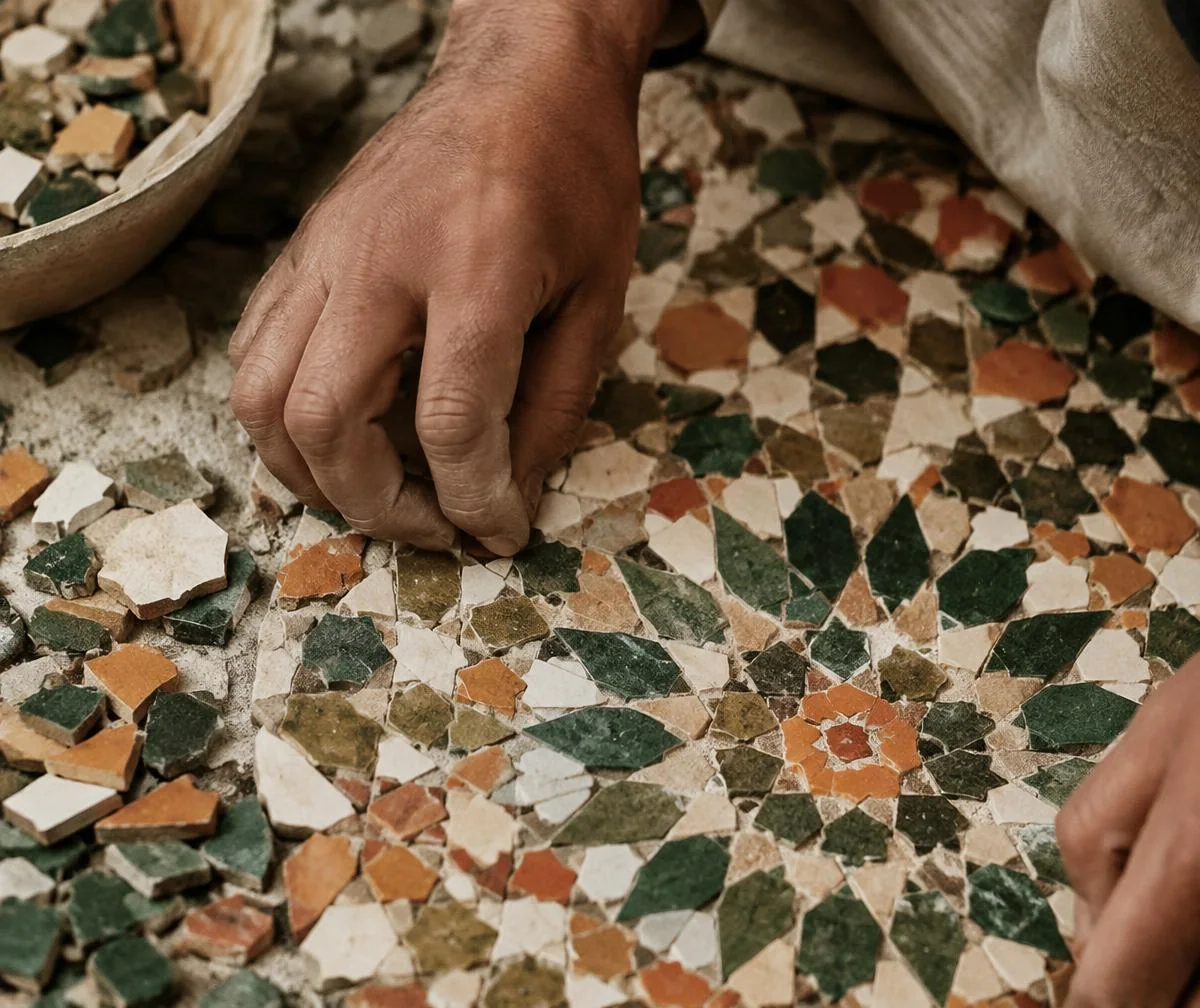 Mani di un artigiano durante la composizione di un mosaico zellige